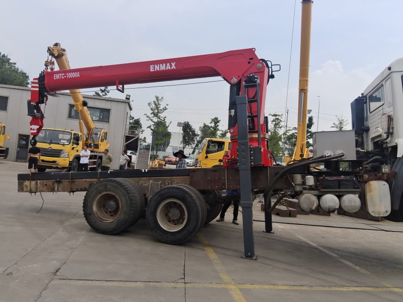 Professional loader crane maintenance and hydraulic system inspection.